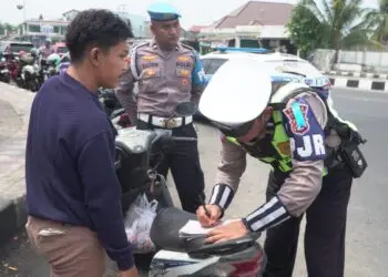 MEMBERIKAN TEGURAN : Personel Polisi Satuan Lalu Lintas Polda Banten, memberikan teguran berupa tilang kepada pengendara motor, karena tidak menggunakan helm. (ISTIMEWA)