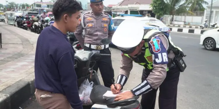 MEMBERIKAN TEGURAN : Personel Polisi Satuan Lalu Lintas Polda Banten, memberikan teguran berupa tilang kepada pengendara motor, karena tidak menggunakan helm. (ISTIMEWA)