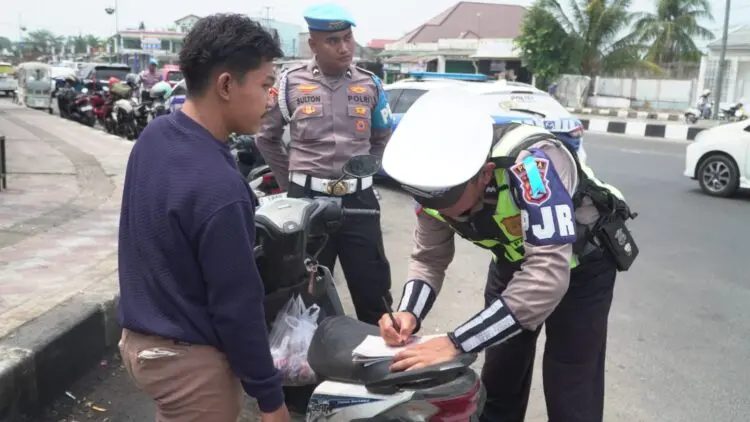MEMBERIKAN TEGURAN : Personel Polisi Satuan Lalu Lintas Polda Banten, memberikan teguran berupa tilang kepada pengendara motor, karena tidak menggunakan helm. (ISTIMEWA)