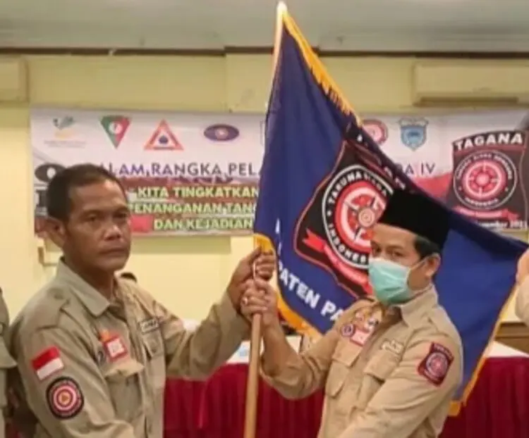 SERAHKAN JABATAN KETUA - Ade Mulyana (kiri), menyerahkan bendera pataka kepada Ketua Tagana Baihaki Rahmat (kanan), saat pergantian Ketua Tagana Kabupaten Pandeglang, beberapa tahun lalu. (ISTIMEWA)
